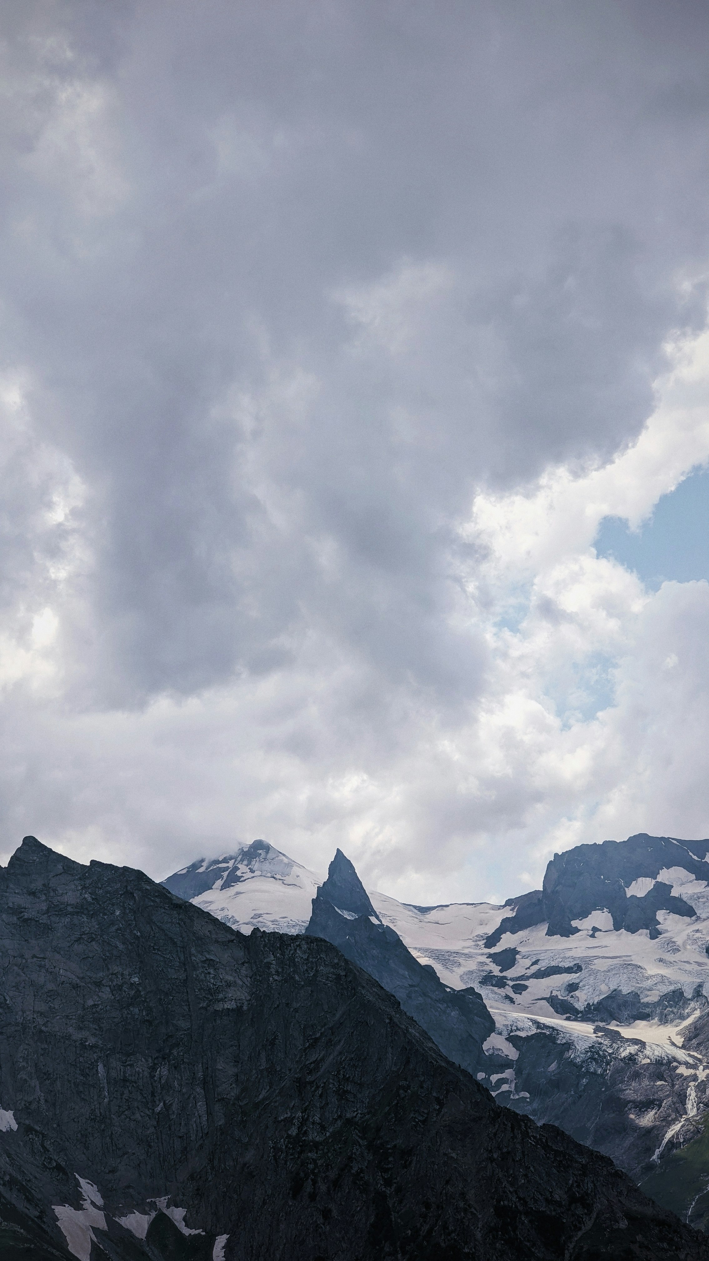 snow covered mountain under cloudy sky during daytime